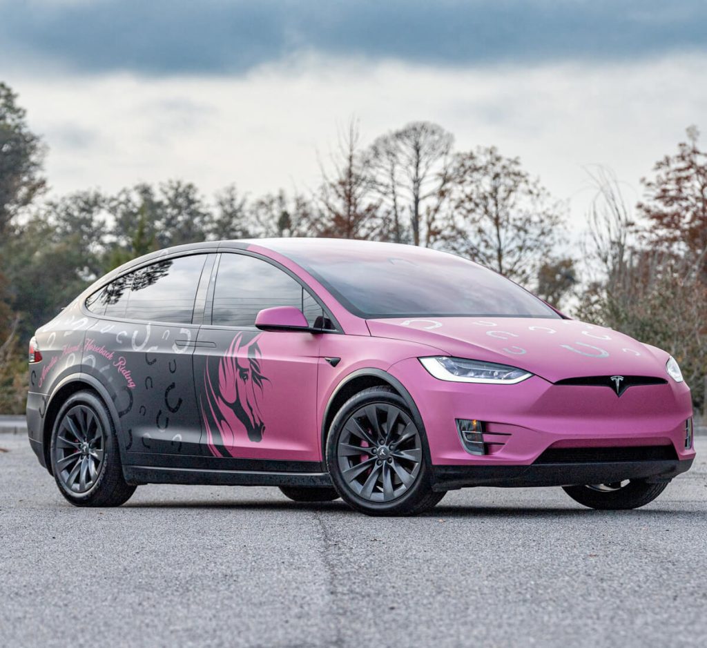 Tesla suv wrapped in pink and black graphics