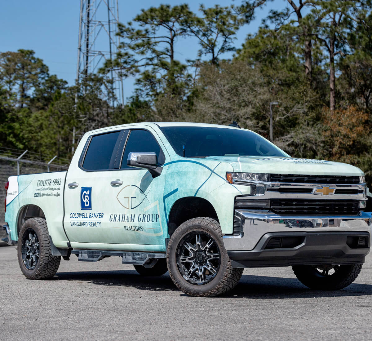 Chevy truck wrapped with white and blue business graphic