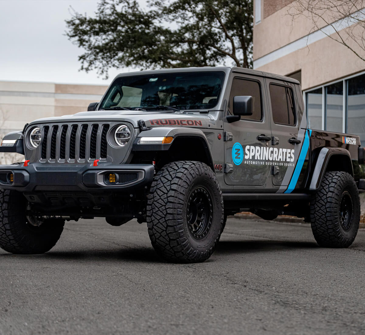 Grey Jeep Rubicon with advertisement of business