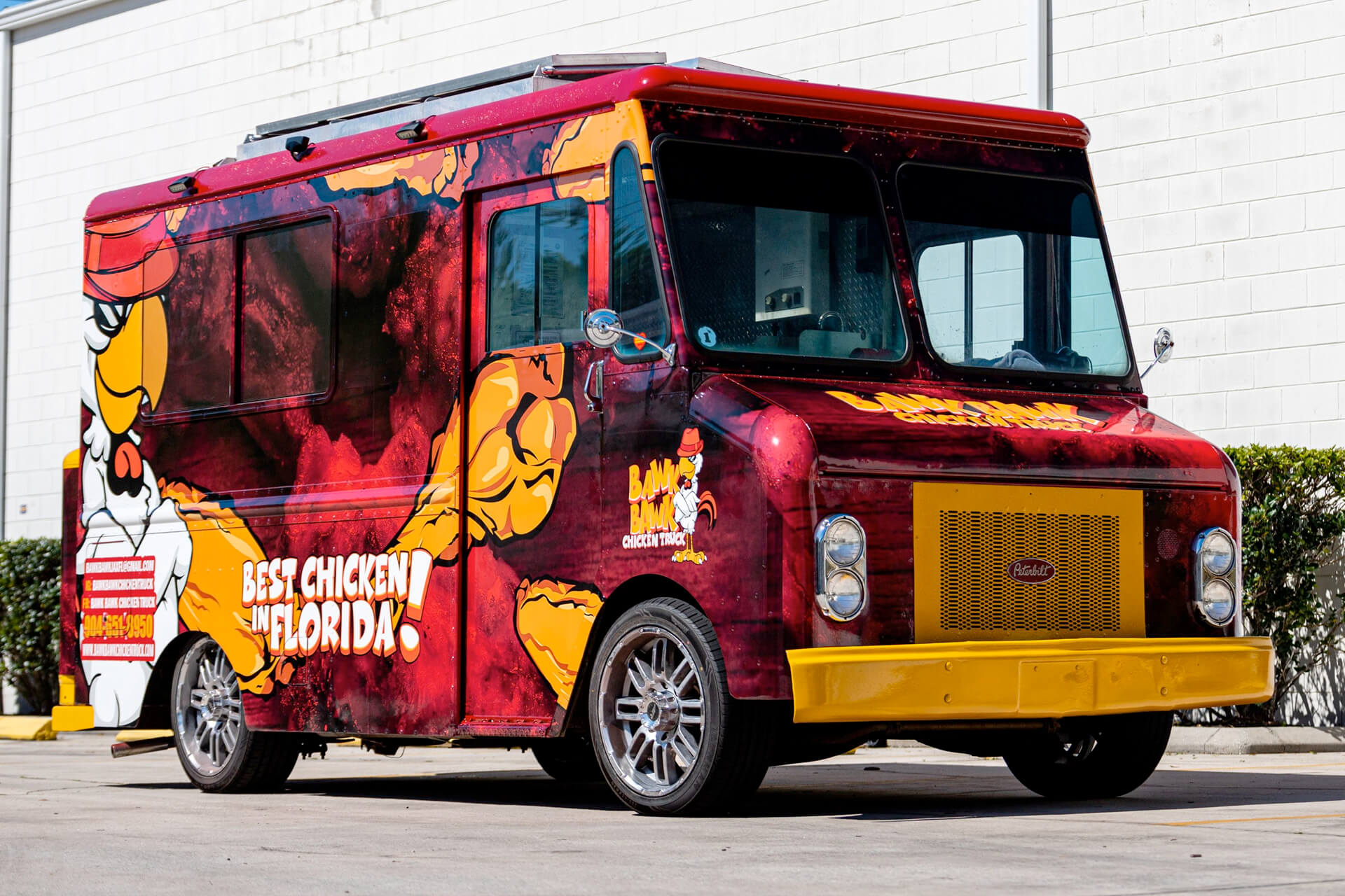 A food truck wrapped in local business graphics.