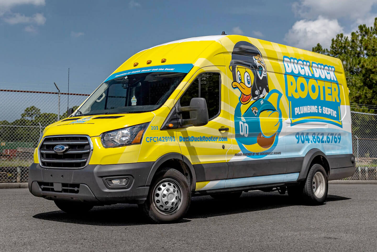A cargo van wrapped in yellow and blue with local business graphics.