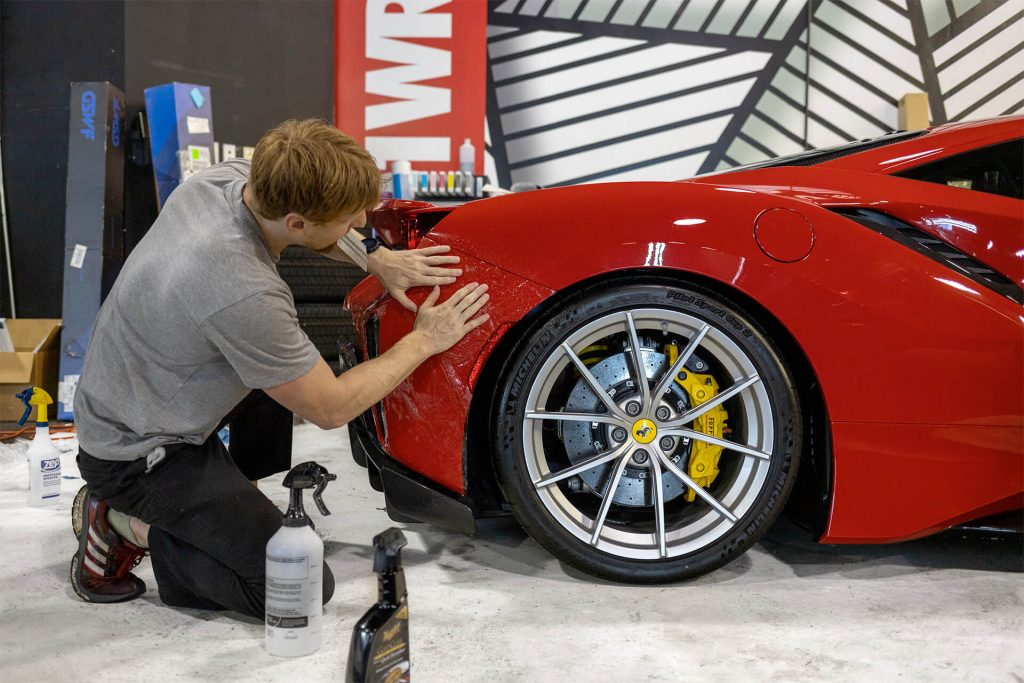 A man working on a red Ferrari.