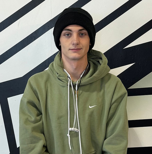 young man in a green nike hoodie and a black beanie